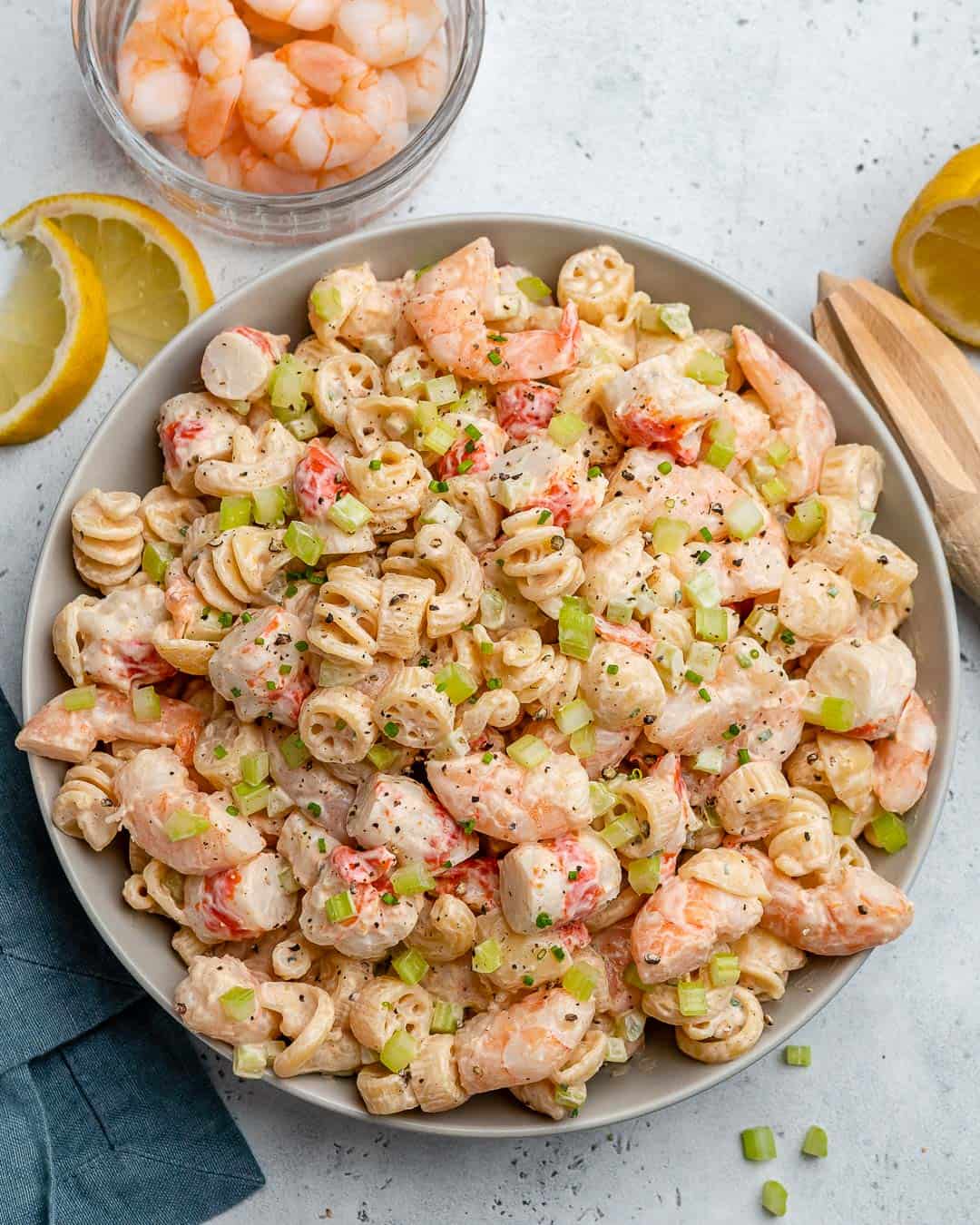 top view of pasta salad with lemon garnishes on the side 