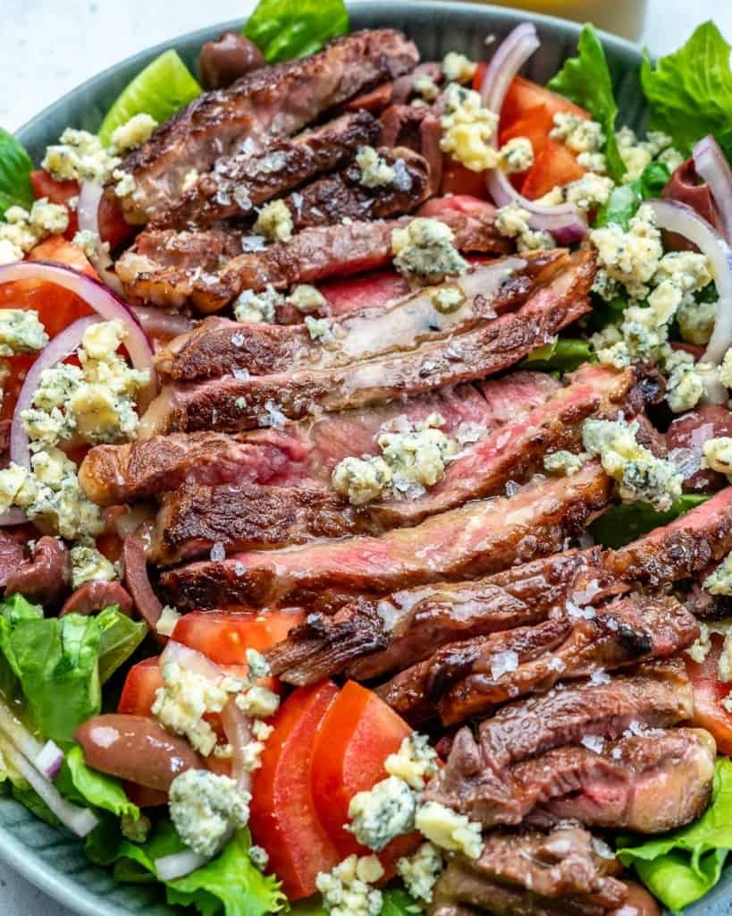 close up of steak salad bowl topped with blue cheese 