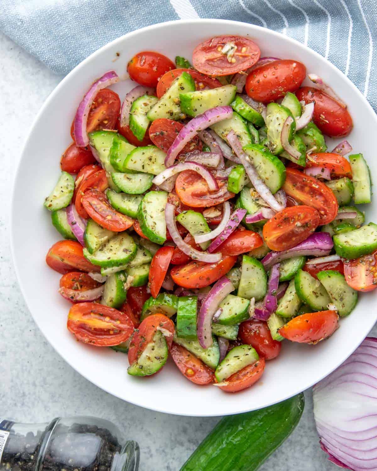 top view of cucumber and tomato salad in a white bowl 