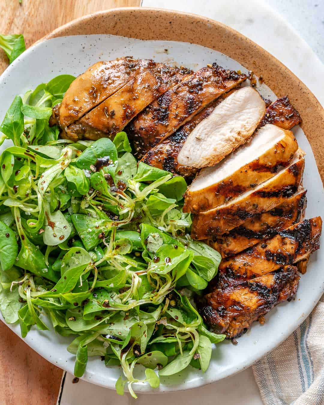Balsamic chicken with a side of green salad on a dish