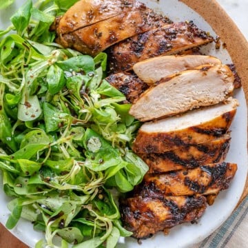 side view of sliced balsamic chicken breast with side green salad