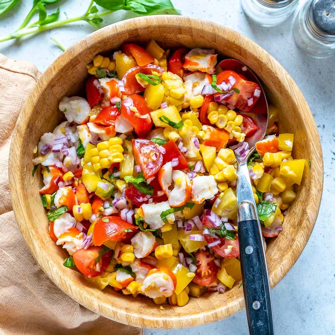 corn tomato and crab salad in a light brown bowl