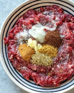 spices on ground beef in a bowl