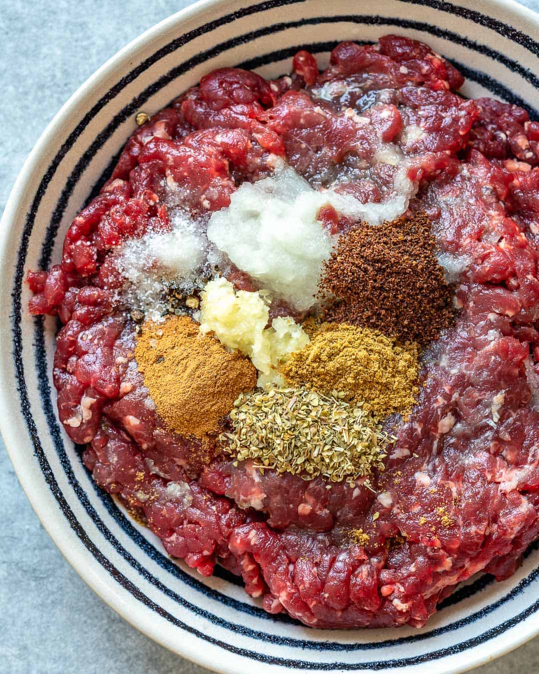 spices on ground beef in a bowl