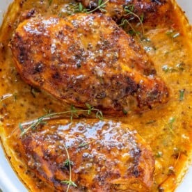 top view baked chicken breast with honey mustard sauce in white dish