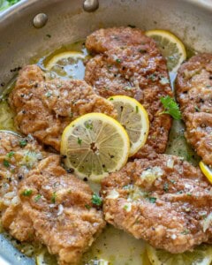 Cooked crispy chicken in a lemon sauce in a skillet.
