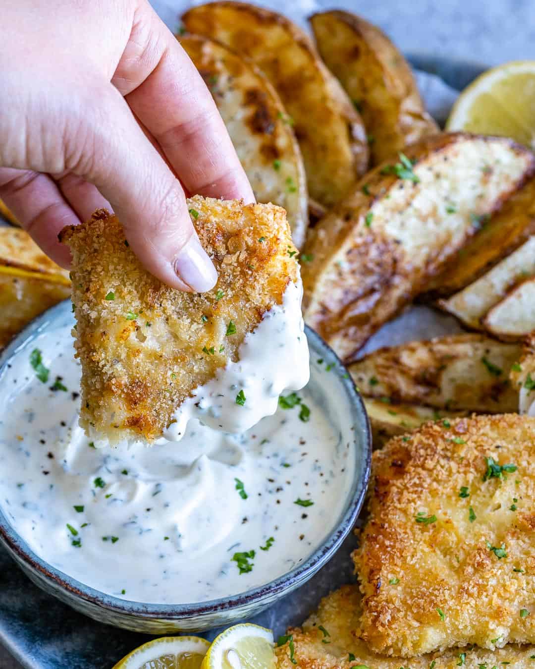 Dipping air fryer fish into sauce. 