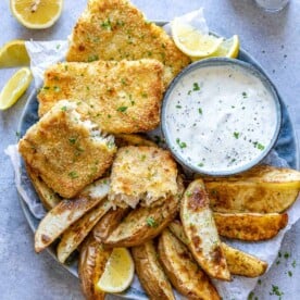 top view air fried fish with potato wedges and white dip