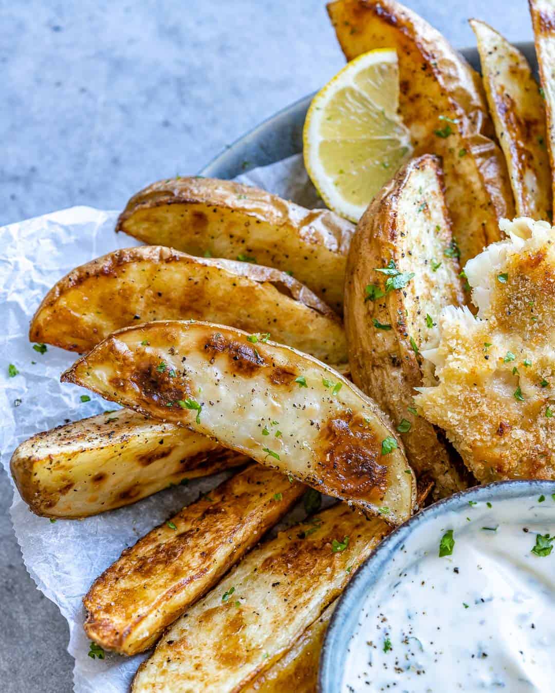 Close up view of crispy potatoes next to fish. 