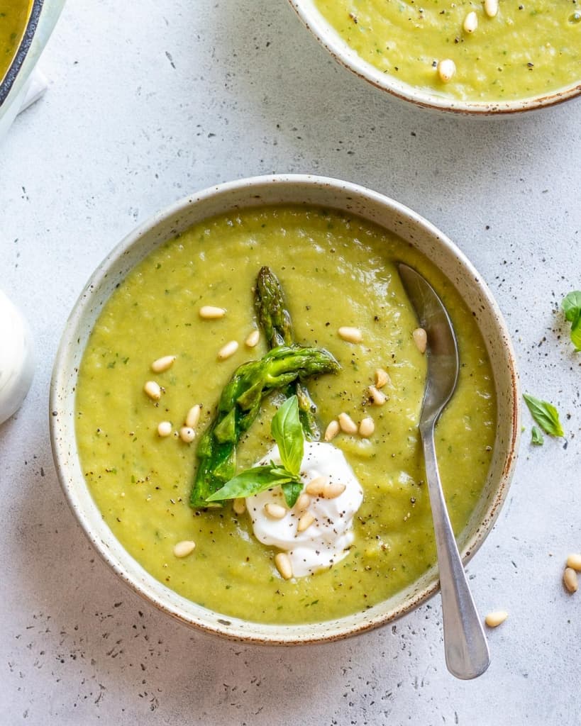 top view of spoon in asparagus soup with greek yogurt granish