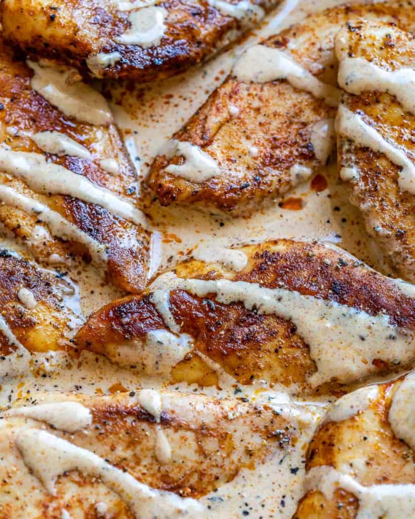close up cajun chicken in a creamy sauce in a pan 