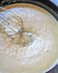 garlic parmesan sauce in pan with whisk.
