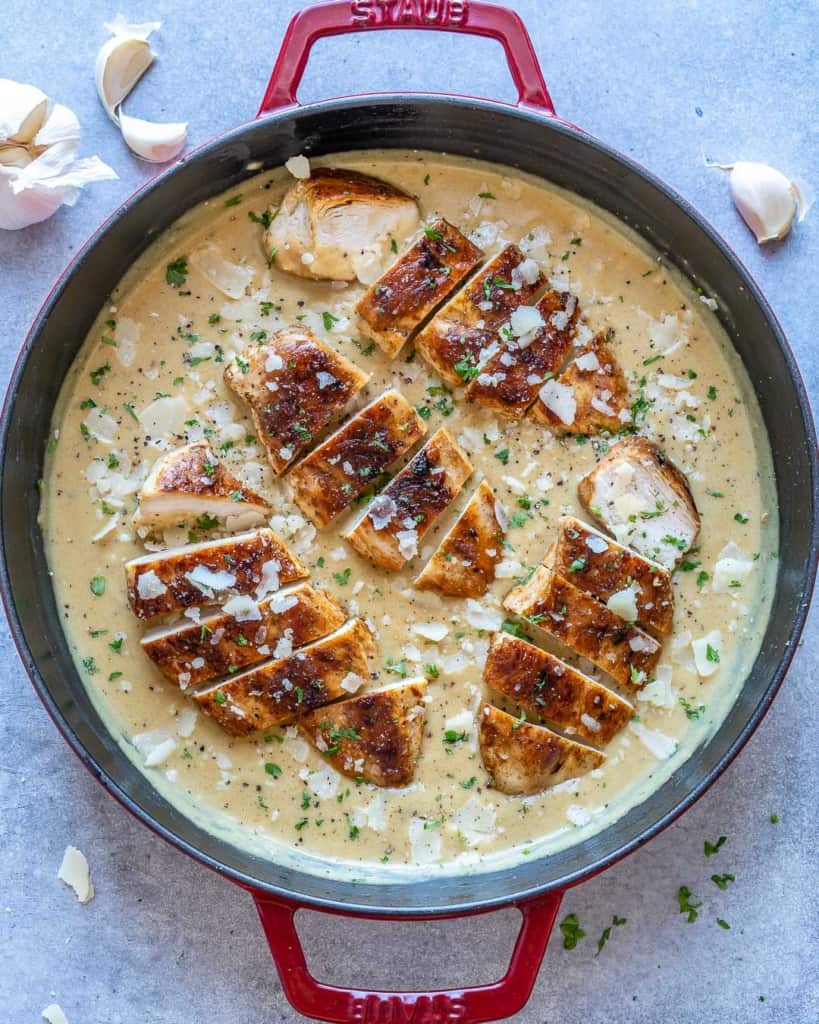 top view of chicken in creamy sauce in red skillet