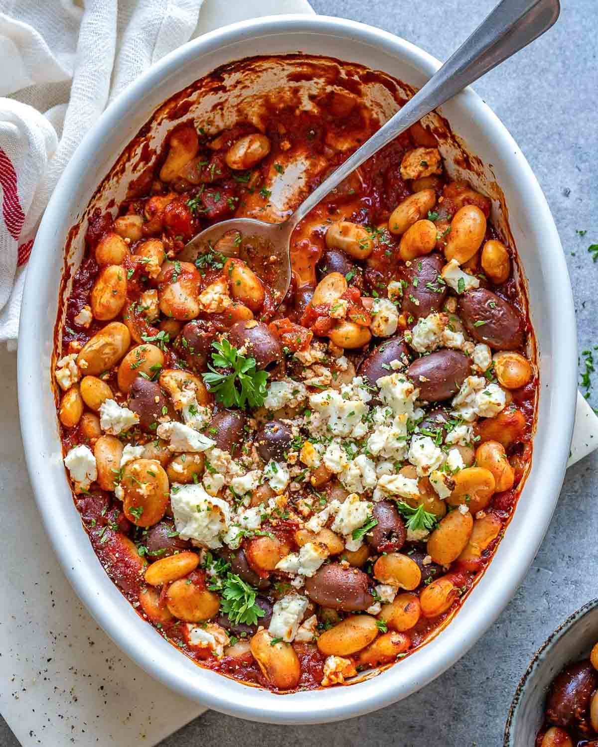 baked beans Greek style in a dish with spoon in the dish.