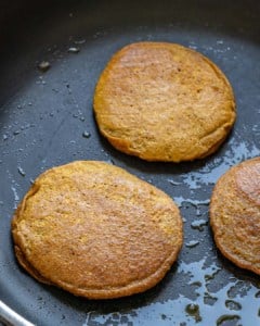 pancakes being cooked in black pan