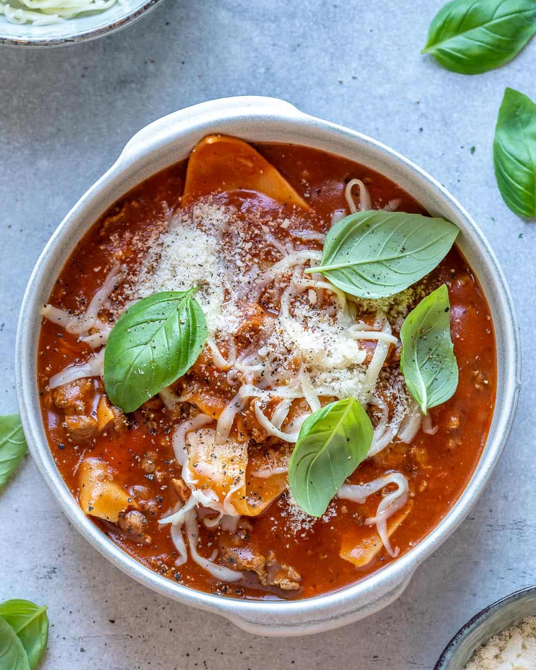 One bowl of one pot lasagna soup with basil and cheese
