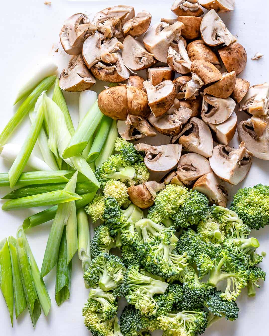 Mushrooms, broccoli, and green onions cut for stir fry. 