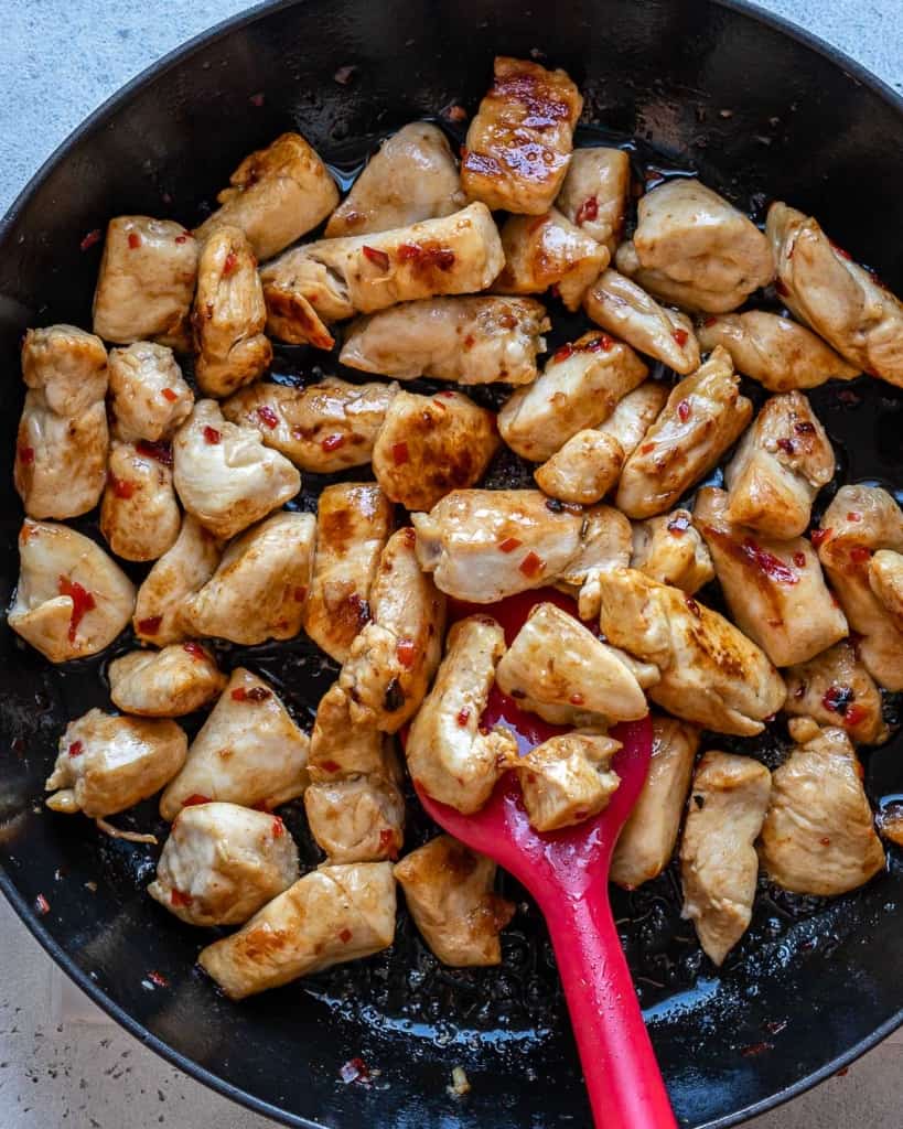 cooking chicken in a black skillet.