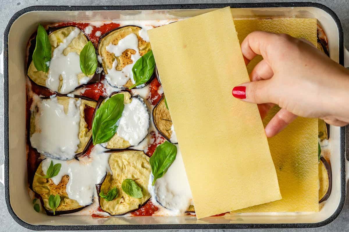 Layering the eggplant lasagna in a dish.