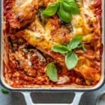 Vegetarian eggplant lasagna in a dish with a slice taken off.