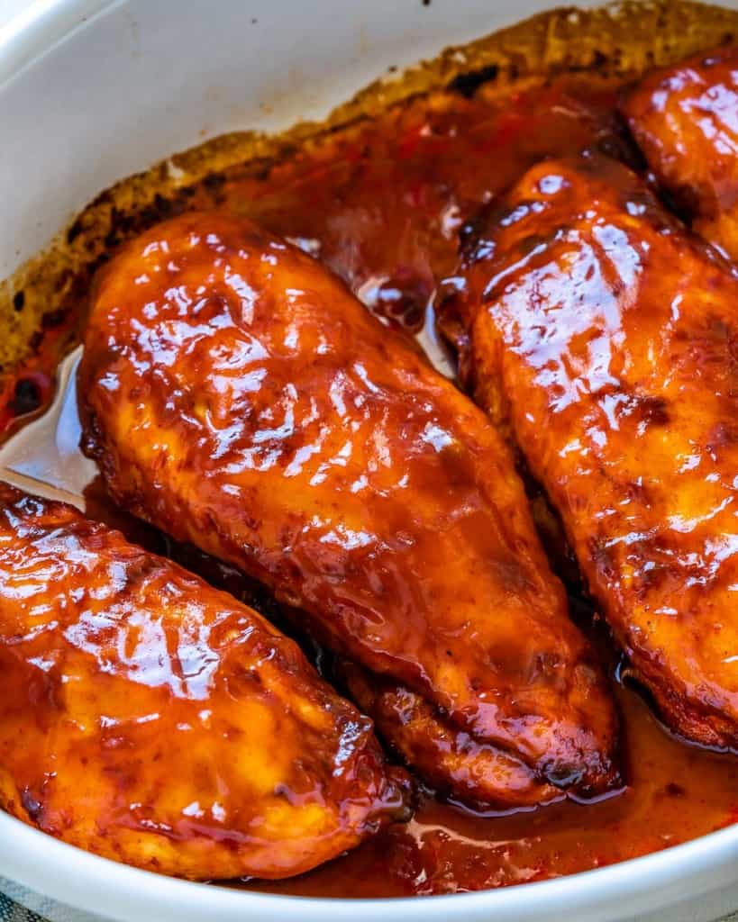 side shot of baked chicken breastt in a white dish