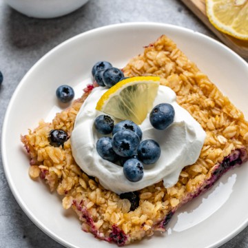side shot of a blueberry oatmeal bake piece on a white plate