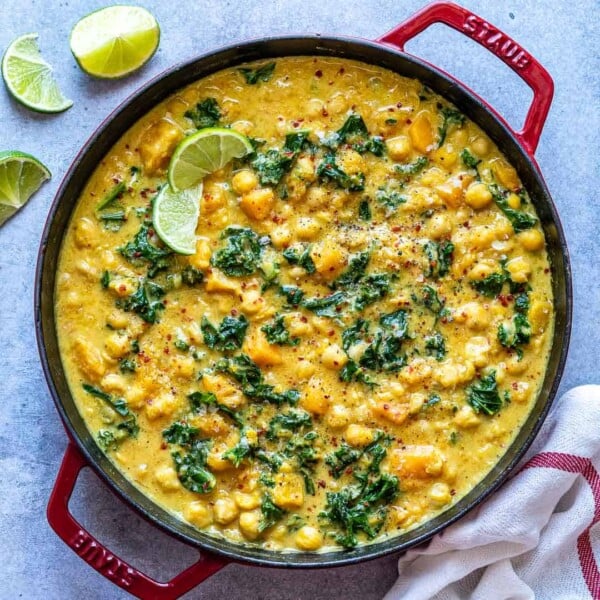 Top down view of chickpea and squash curry in a red pot.