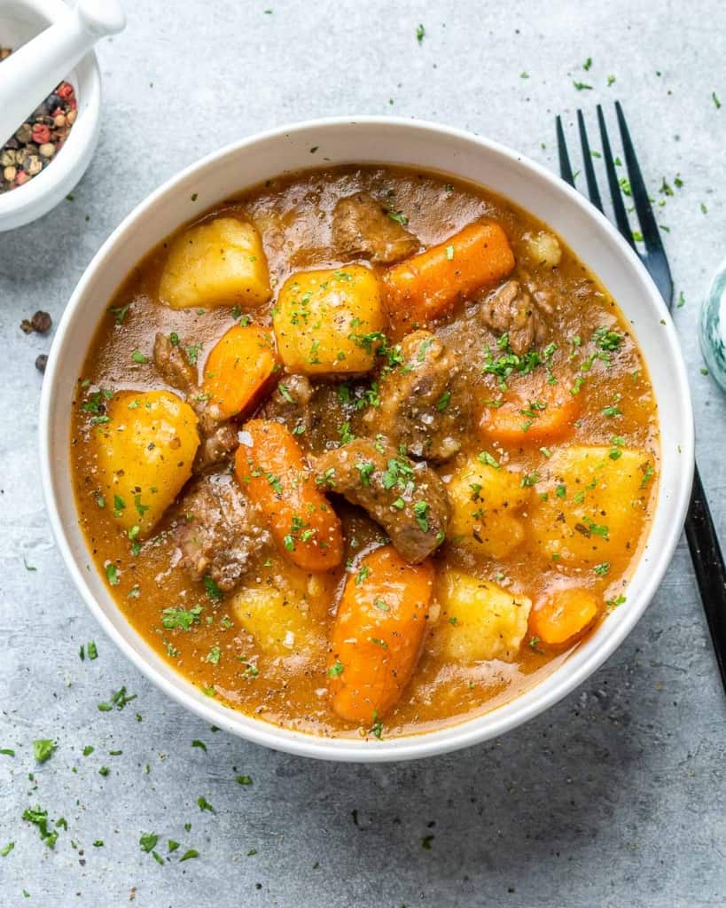 A bowl of instant pot beef stew with a fork on the side.