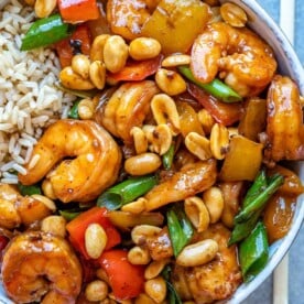 Top view of kung pao shrimp in white bowl