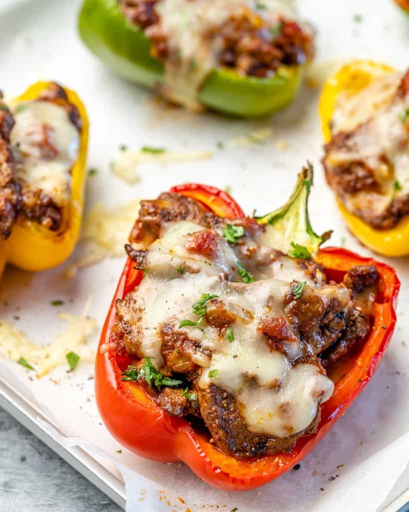 Four stuffed peppers on a baking sheet. 