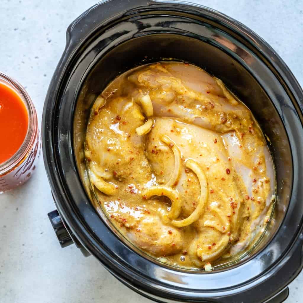 Chicken breasts cooking in Crockpot with spices