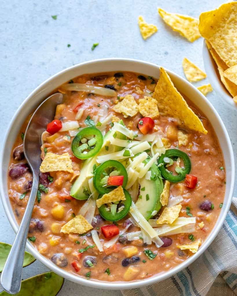 spoon in the bowl of tortilla soup with toppings