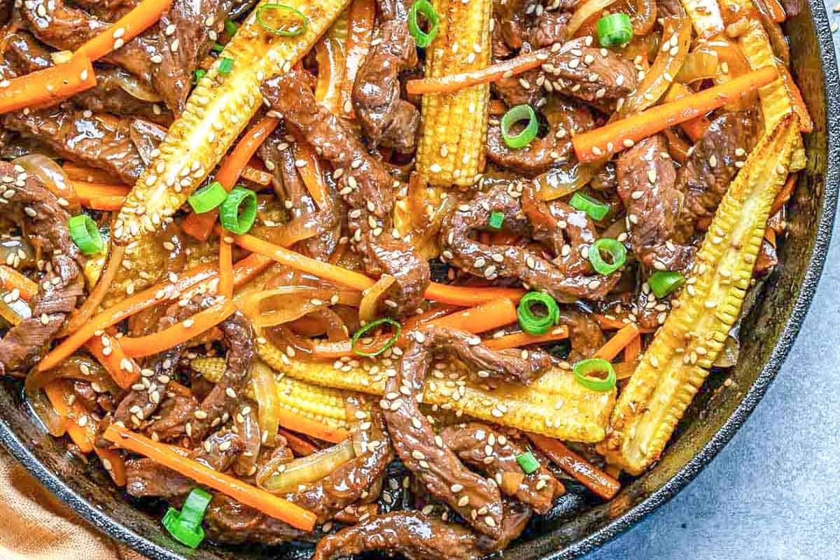 Beef stir fry with veggies in a skillet.