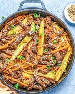 Beef stir fry with veggies in a skillet.