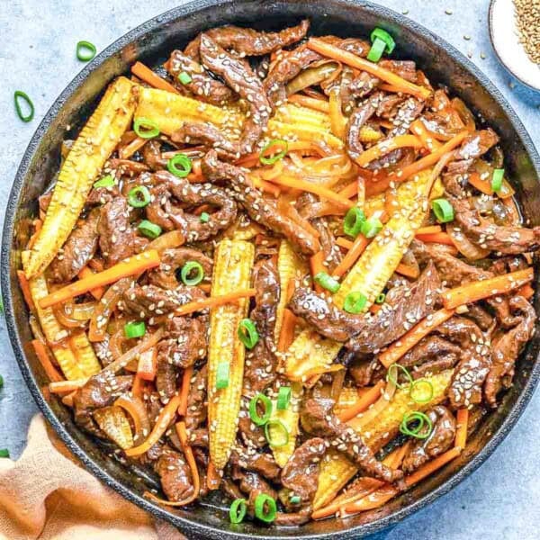 Beef stir fry in a black skillet.