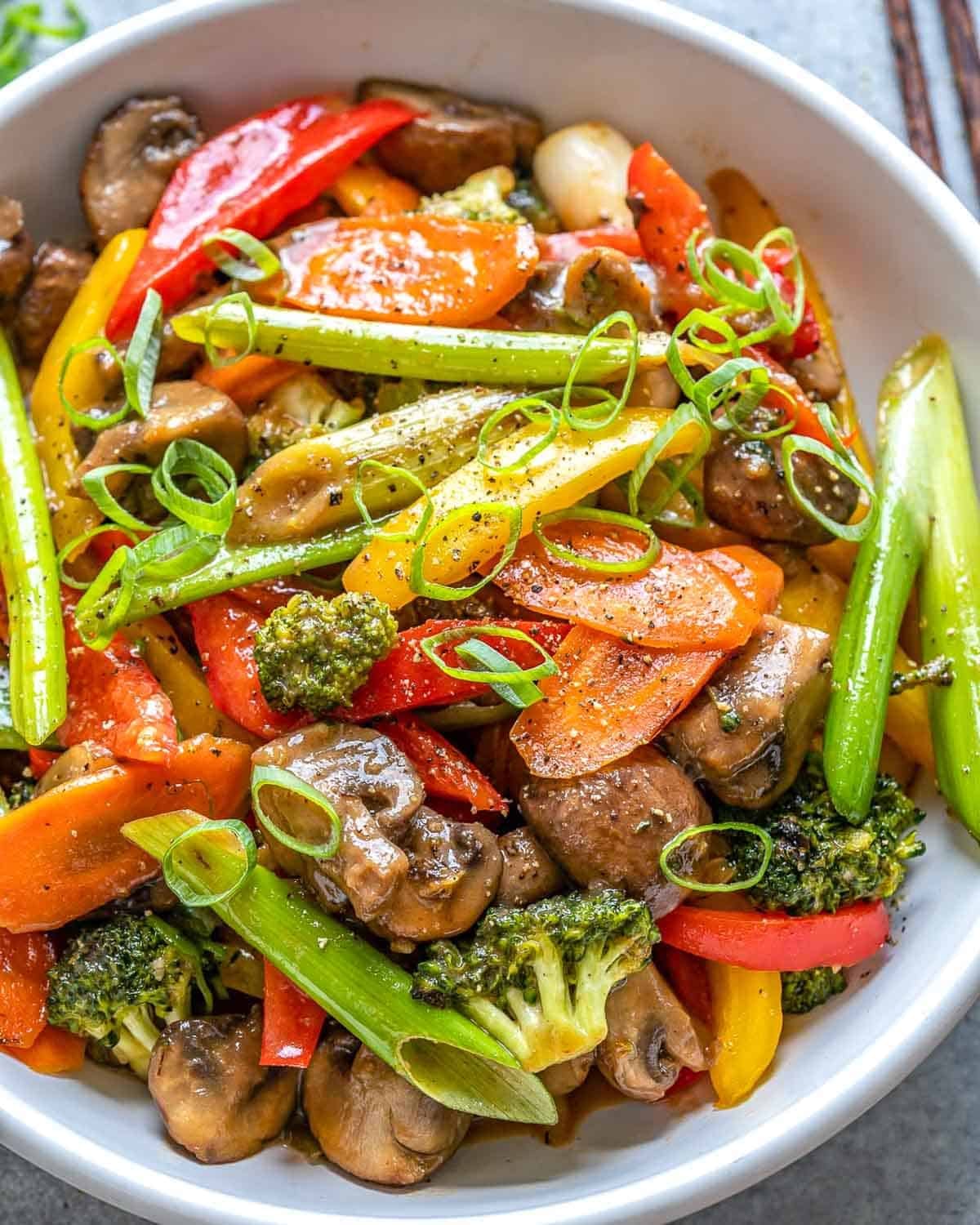 a round white bowl filled with stir fried veggies.