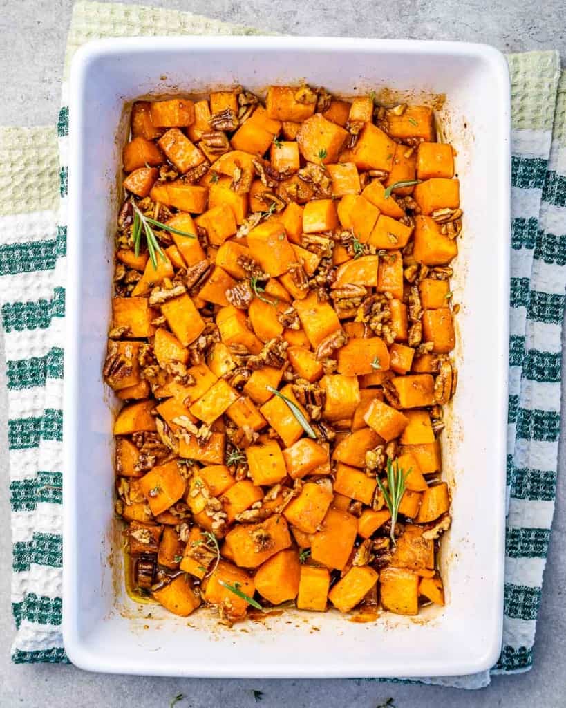 Overhead view of maple roasted sweet potatoes in a long white baking dish. 