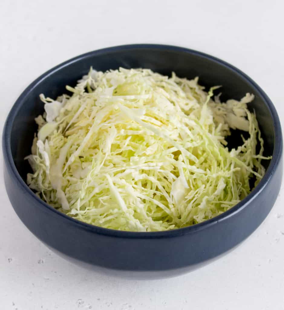 Shredded white cabbage in black bowl