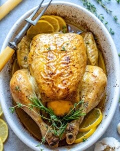 whole roasted chicken in a baking dish.