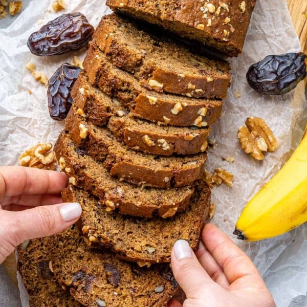 slices of banana bread with hand holding a slice