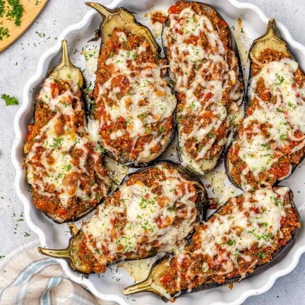 Top down view of eggplant with beef stuffing in a dish.