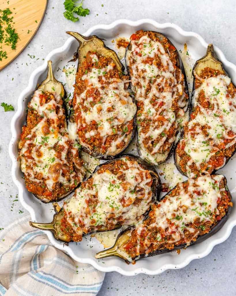 Top down view of eggplant with beef stuffing in a dish.
