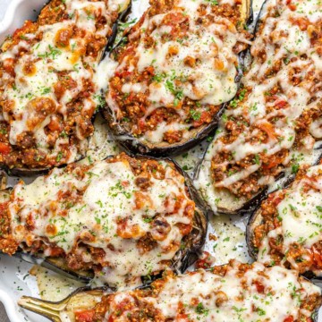 Top down view of stuffed eggplants in a dish.