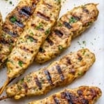 close up top view of grilled chicken kafta on a white platter