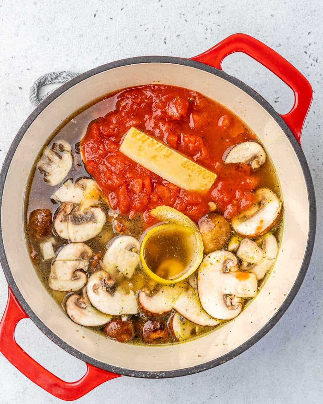 tomatoes added to pot with Parmesan and lemon rind and mushrooms 