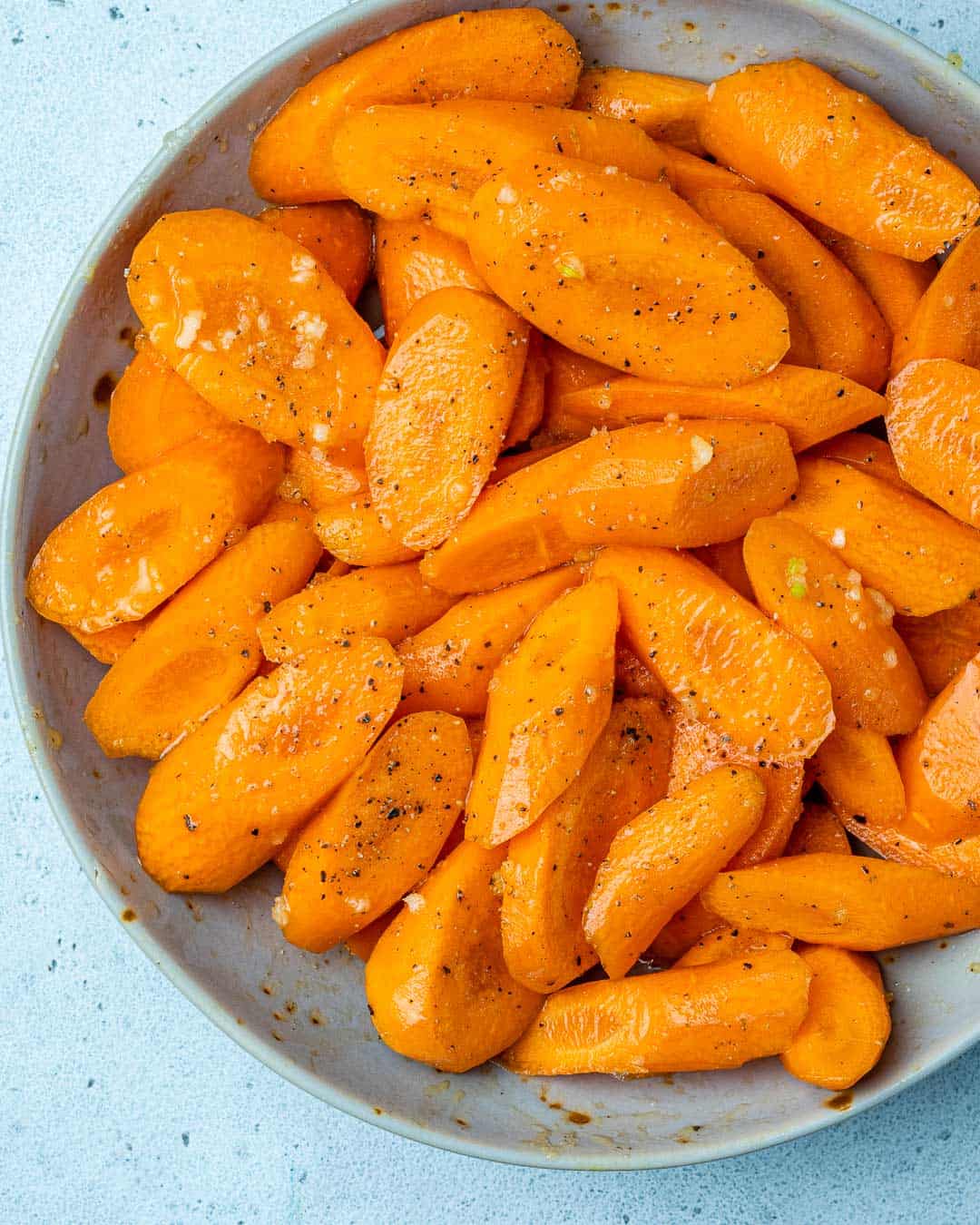 Sliced carrots in bowl tossed with honey glaze