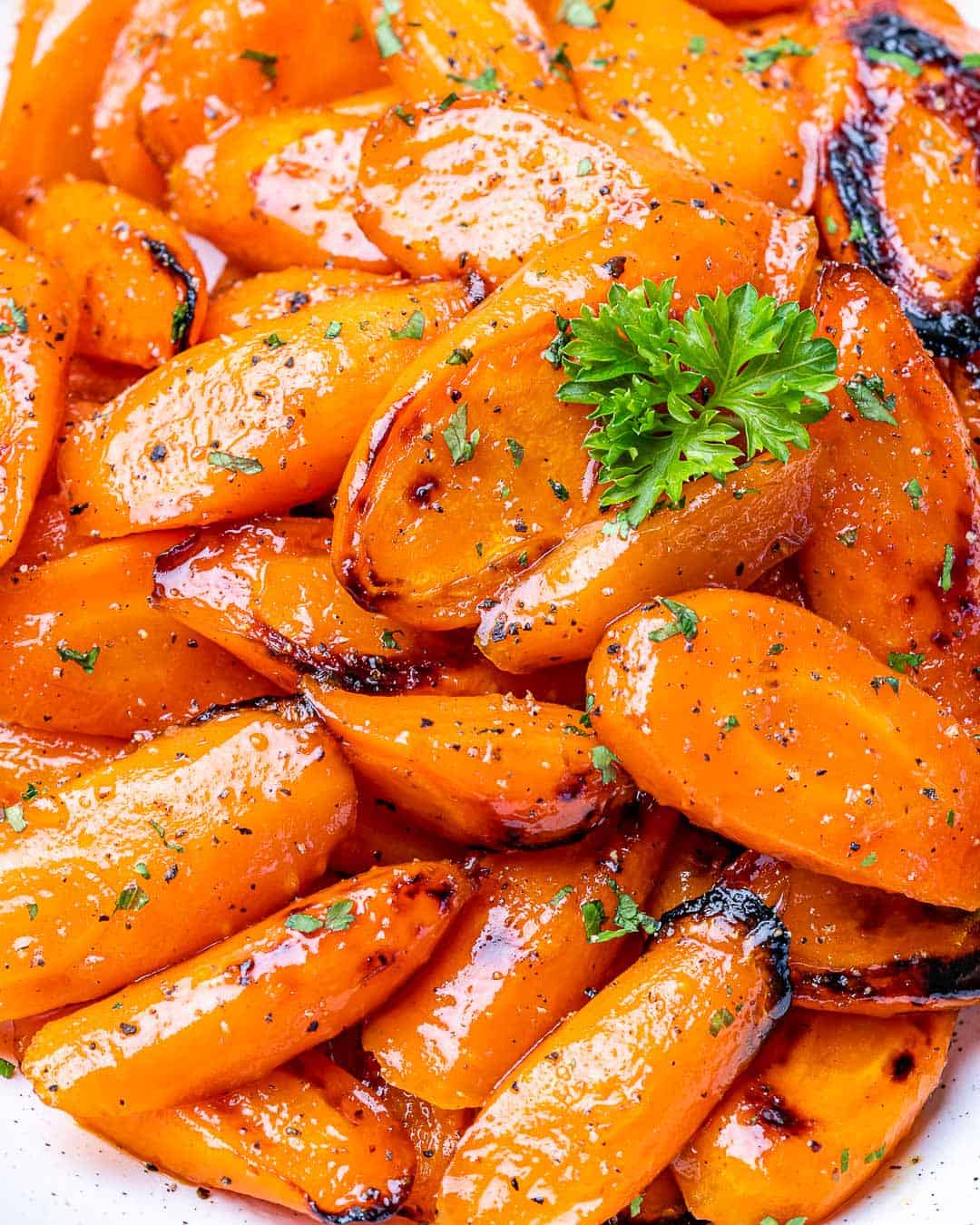 Spoon scooping honey glazed carrots from bowl