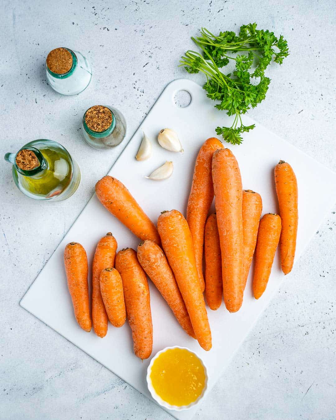 Ingredients for honey glazed carrots on cutting board