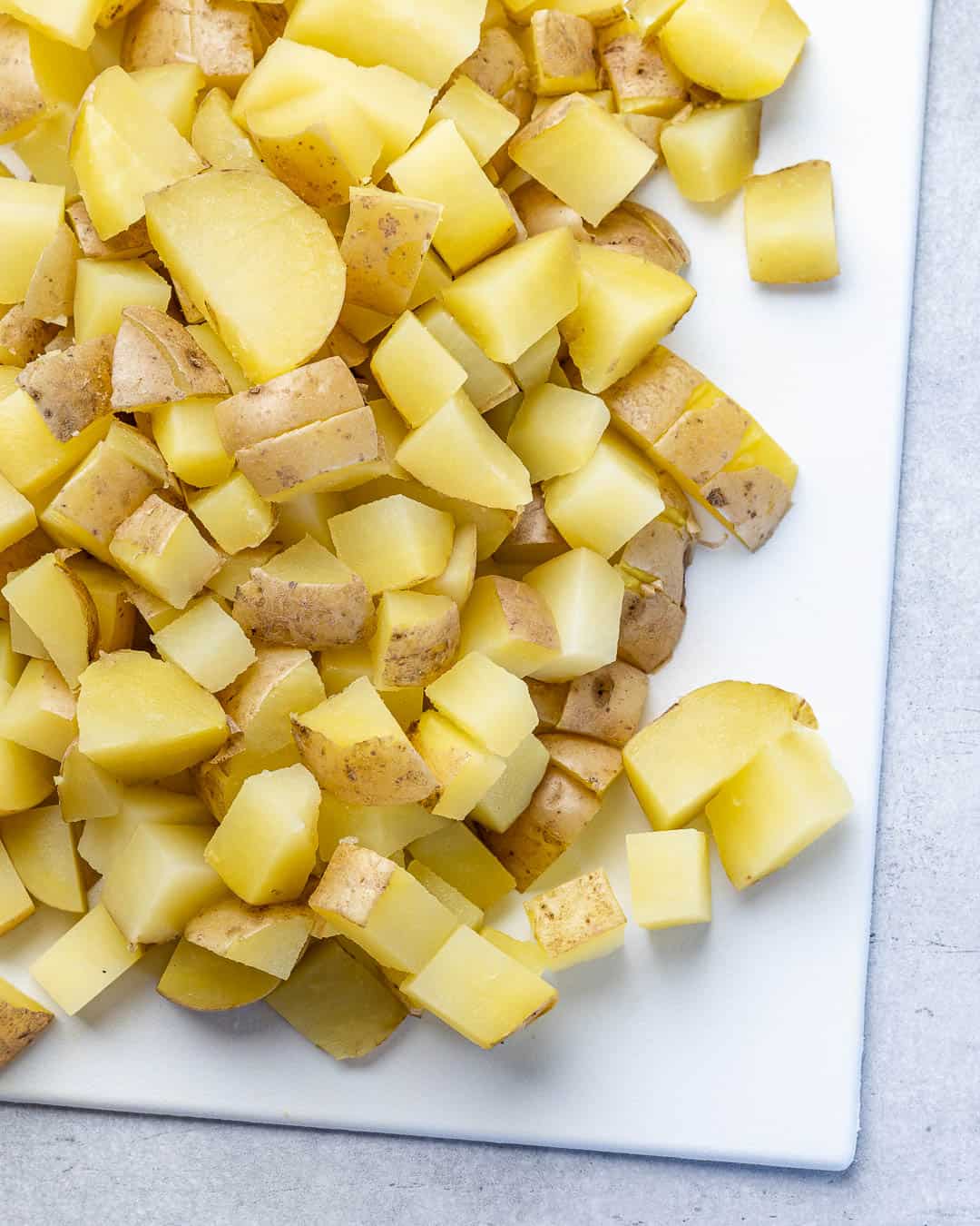 Potatoes cooked and chopped on cutting board
