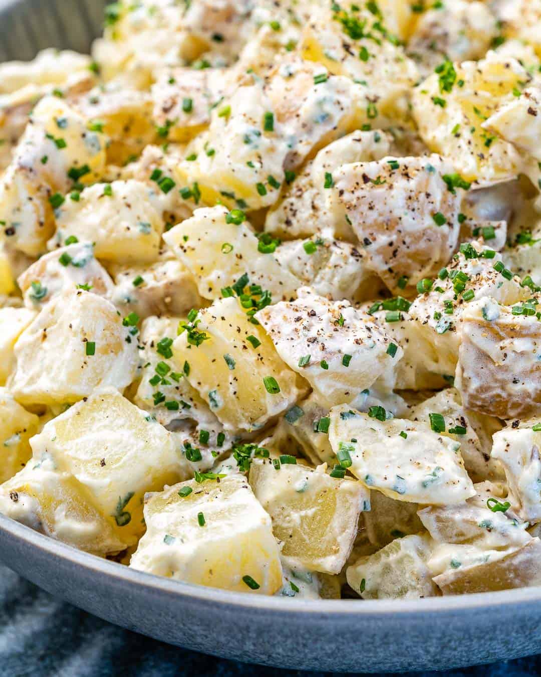 Really close view of easy mustard sauce on potato salad in gray bowl